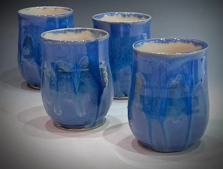 A group of blue cups sitting on top of a table.