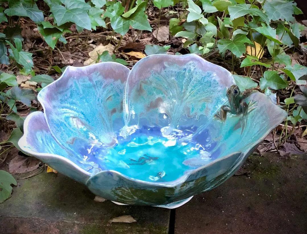 A bowl that is made of glass and has leaves on it.