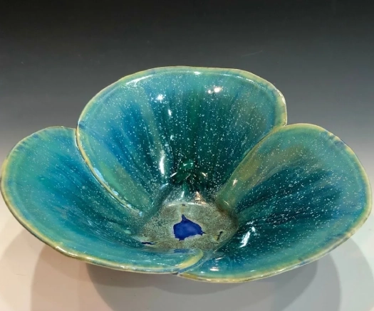 A blue bowl with a flower design on it.