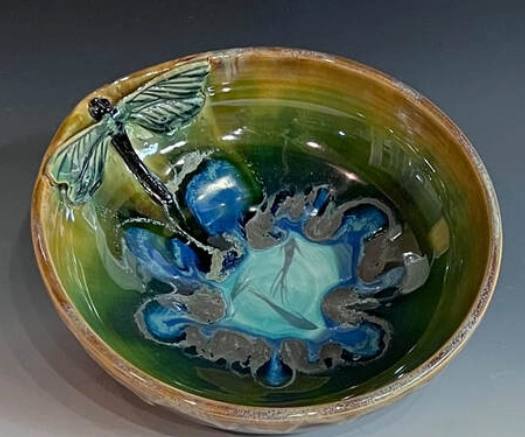 A bowl with a green and blue design on it.